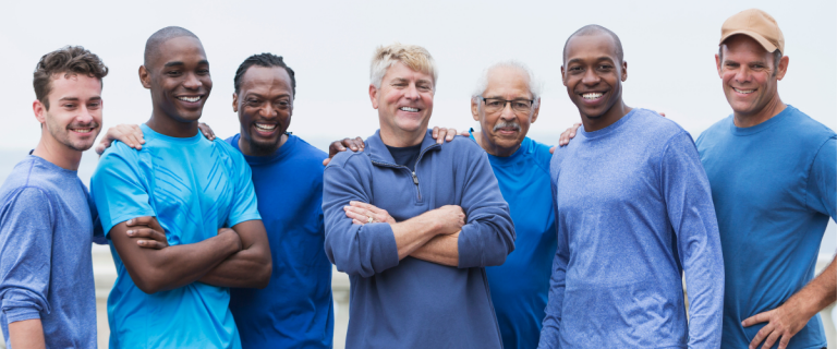 A diverse group of smiling employees standing together outdoors.