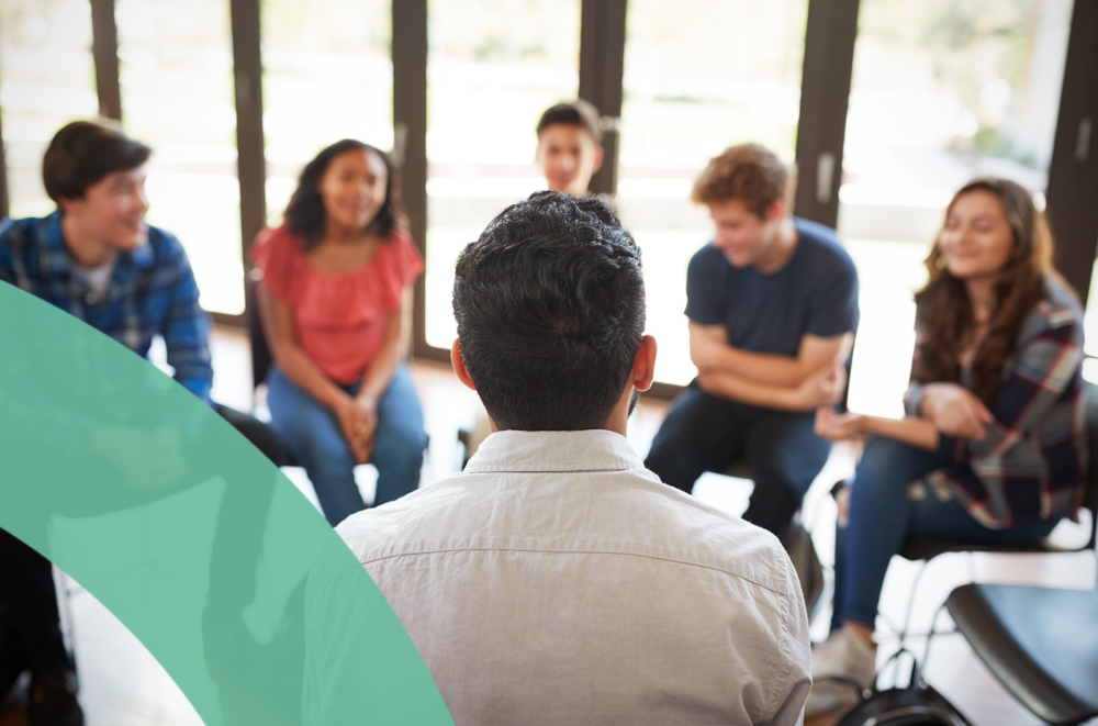 A group discussion in a bright room facilitated by an employee assistance professional.