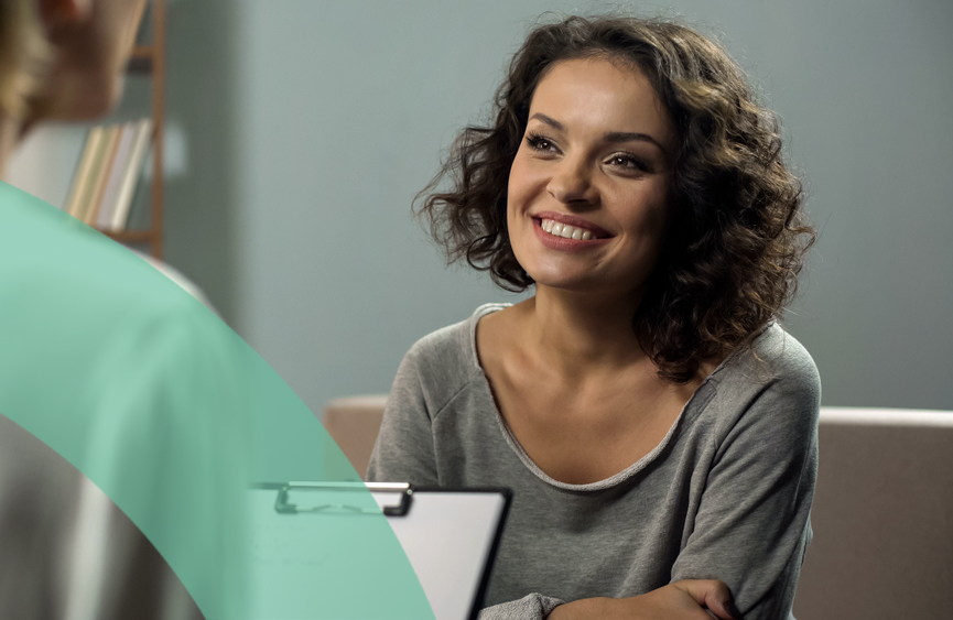 Smiling woman engages in a supportive conversation with a counselor.