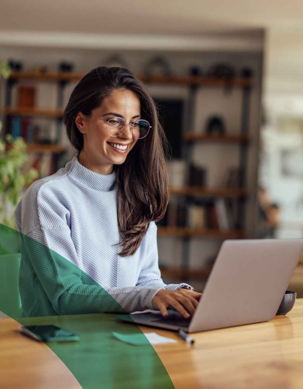 A woman works on her laptop while seated in a cozy modern home office space.